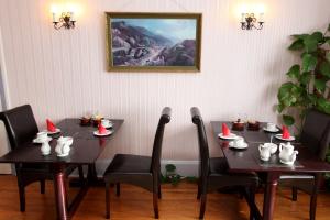 uma sala de jantar com duas mesas com chapéus de Pai Natal em Cranston House em East Grinstead