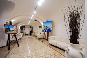 a living room with white couches and a painting at Amalfi Hotel centro storico in Amalfi