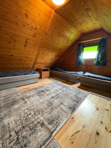an attic room with two beds and a window at Domki Lazur in Jastrzębia Góra