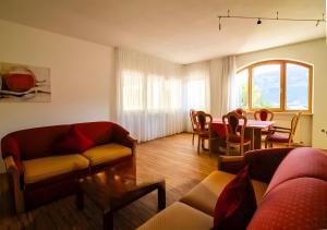 a living room with couches and a table and a dining room at Bio Wellnesshotel Pazeider in Marlengo