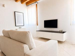 a living room with a couch and a tv at Appartamento Donà 2 in Rovigo +2 photos