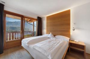 a bedroom with a large bed and a large window at Bio Wellnesshotel Pazeider in Marlengo +152 photos
