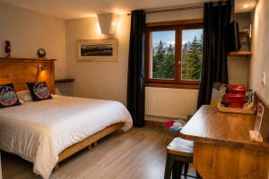 a bedroom with a bed and a window at Hotel la Fontaine du Mont Blanc in Les Houches