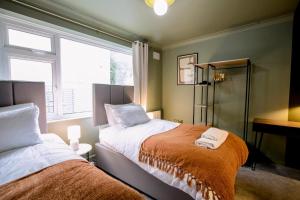 a bedroom with two beds and a window at The Whitehouse - Flat B in Carbis Bay