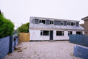 a large white house with a fence in front of it at The Whitehouse - Flat B in Carbis Bay
