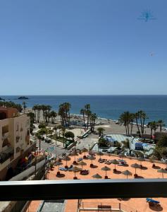a view of a beach with umbrellas and the ocean at ESTUDIOS CHINASOL - Bernardo Cózar in Almuñécar