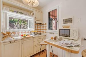a kitchen with white cabinets and a table with a microwave at Villa Aurora with Sea View in Seravezza