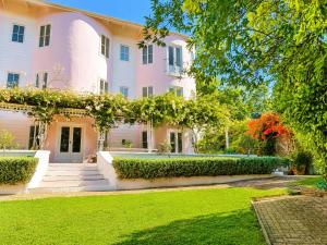a large pink house with a green yard at Constantia The Silos in Sweet Valley