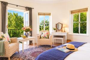 a bedroom with a bed and chairs and a mirror at Constantia The Silos in Sweet Valley