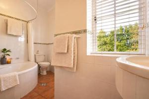 a bathroom with a tub and a sink and a toilet at Constantia The Silos in Sweet Valley