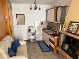 a living room with a couch and a kitchen at Casa Sandrina in Caprino Veronese