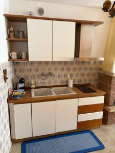a kitchen with white cabinets and a sink at Casa Sandrina in Caprino Veronese
