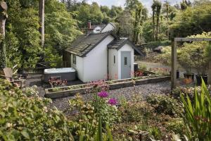 a small house in the middle of a garden at The Cosy Cottage - Ridgestone in Bowness-on-Windermere