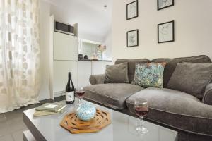 a living room with a couch and a table with wine glasses at The Cosy Cottage - Ridgestone in Bowness-on-Windermere