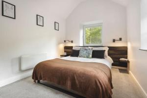 a bedroom with a large bed and a window at The Cosy Cottage - Ridgestone in Bowness-on-Windermere