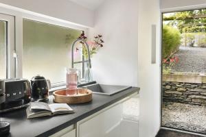a kitchen counter with a sink and a window at The Cosy Cottage - Ridgestone in Bowness-on-Windermere