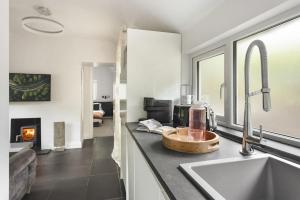 a kitchen counter with a sink and a fireplace at The Cosy Cottage - Ridgestone in Bowness-on-Windermere +13 photos