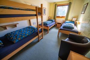a room with two bunk beds and a chair at Torridon Youth Hostel in Torridon