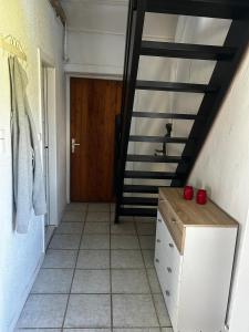 a bathroom with a staircase with red apples on a dresser at Small house in rural surroundings in Gelstrup +4 photos