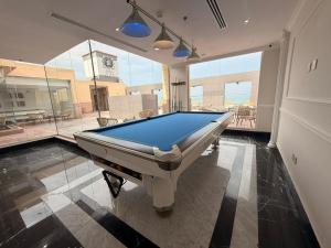 a pool table in a room with a large window at فندق اهلا للشقق الفندقية in Al Jubail