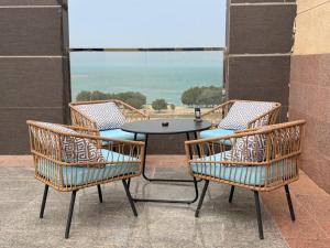 a table and chairs on a balcony with a view of the ocean at فندق اهلا للشقق الفندقية in Al Jubail