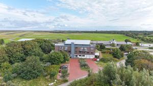 an aerial view of a building with trees and a field at Strandwetter Dünenhotel in Borkum