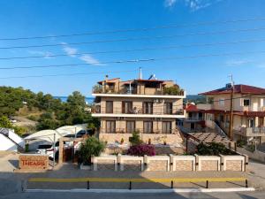 a building in a parking lot in front of a building at THEASIS 4 luxury studio with sea view in Neos Marmaras