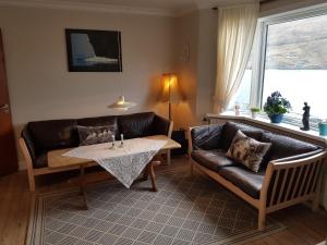 a living room with a couch and a table at Budget Guesthouse Borgustova in Vestmanna