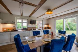 a kitchen with a wooden table and blue chairs at Haus Tadder in Born
