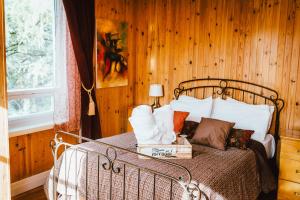 um quarto com uma cama e uma parede de madeira em Gîte TerreCiel em Baie-Saint-Paul