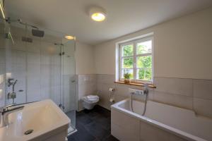 a bathroom with a tub and a toilet and a sink at Haus Tadder in Born +24 photos
