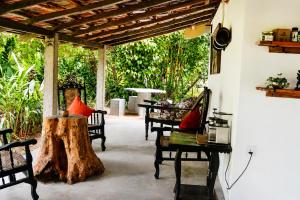 a patio with chairs and a tree stump at Luminosium Nature Retreat & Heritage Forest Garden in Pannala +39 photos