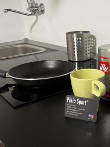 a frying pan on a stove with a yellow bowl at Monolocale Cerreto Laghi in Cerreto Laghi