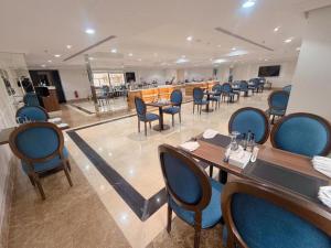 a restaurant with tables and chairs and a bar at فندق اهلا للشقق الفندقية in Al Jubail