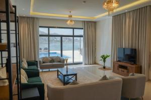 a living room with a couch and a tv at Al Dana H2O Beachfront Villa with a private pool, Al Dana Island Sharm Fujairah in Sharm