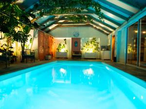 a swimming pool in a house with a ceiling at L'Ecrin des Roches in Le Langon