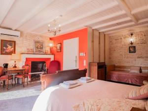 a bedroom with red walls and a bed and a desk at L'Ecrin des Roches in Le Langon