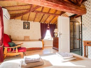 a bedroom with a bed and a red chair at L'Ecrin des Roches in Le Langon +19 photos