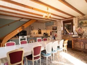 a large kitchen with a long table and chairs at L'Ecrin des Roches in Le Langon