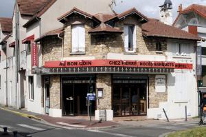 an old building on the corner of a street at Hôtel Au Bon coin chez Pierre in Franconville