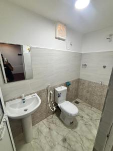 a bathroom with a toilet and a sink at Backpackers inn Hostel in Trincomalee