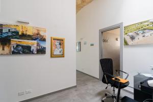 an office with three paintings on the wall and a chair at Villa Queen by Perle di Puglia in Lecce