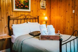 Una cama en una habitación de madera con una caja. en Gîte TerreCiel en Baie-Saint-Paul
