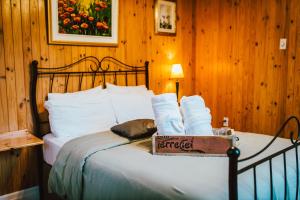 a bed in a wooden room with a box on it at Gîte TerreCiel in Baie-Saint-Paul