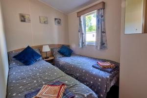 a bedroom with two beds and a window at Finest Retreats - Seascape in Porchfield