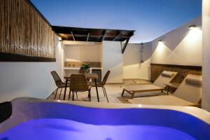 a living room with a table and chairs and a tub at ARCH Luxury Suites in Archangelos