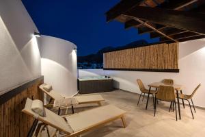 a patio with chairs and a table on a roof at ARCH Luxury Suites in Archangelos
