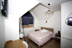 a small bedroom with a bed and a window at Hôtel Au Bon coin chez Pierre in Franconville