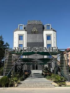 a building with a welcome sign in front of it at Royal Hotel Navoi in Navoi