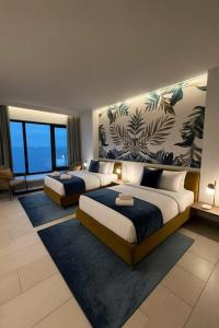 two beds in a hotel room with windows at Mayott By Vilaastaa in Indore